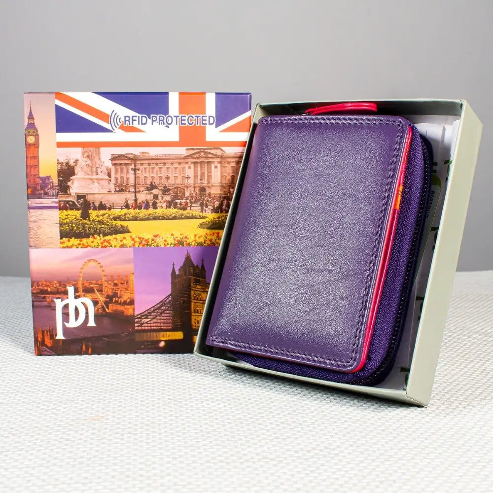 Purple wallet with red interior in a box featuring British landmarks and 'RFID PROTECTED' text.