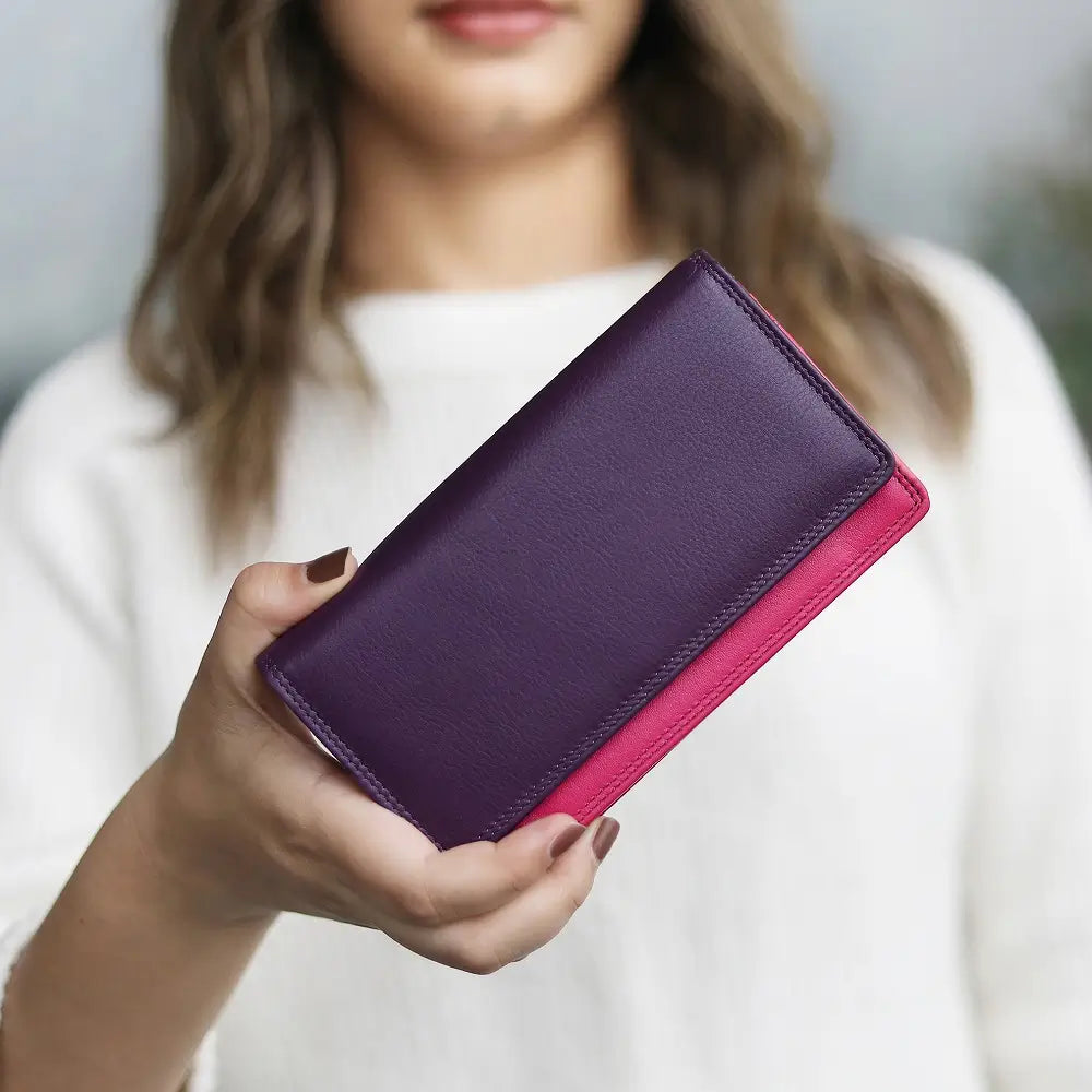 Person holding  Purple wallet with pink bottom section on a white background