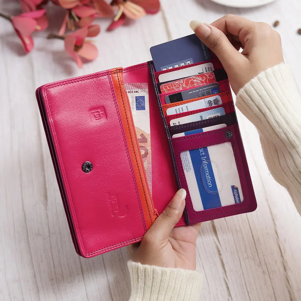 Person holding  Purple wallet with pink bottom section on a white background
