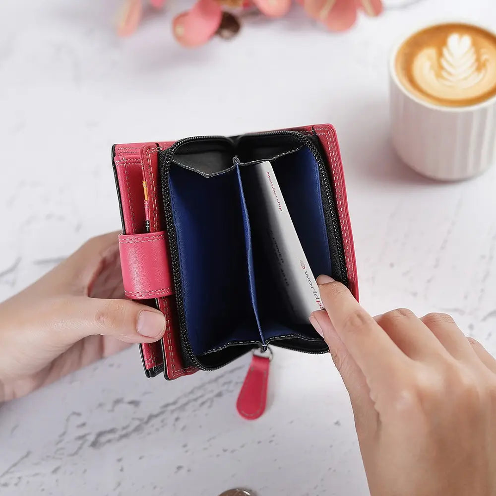 Person opening a Purple wallet with a cup of coffee and flowers in the background