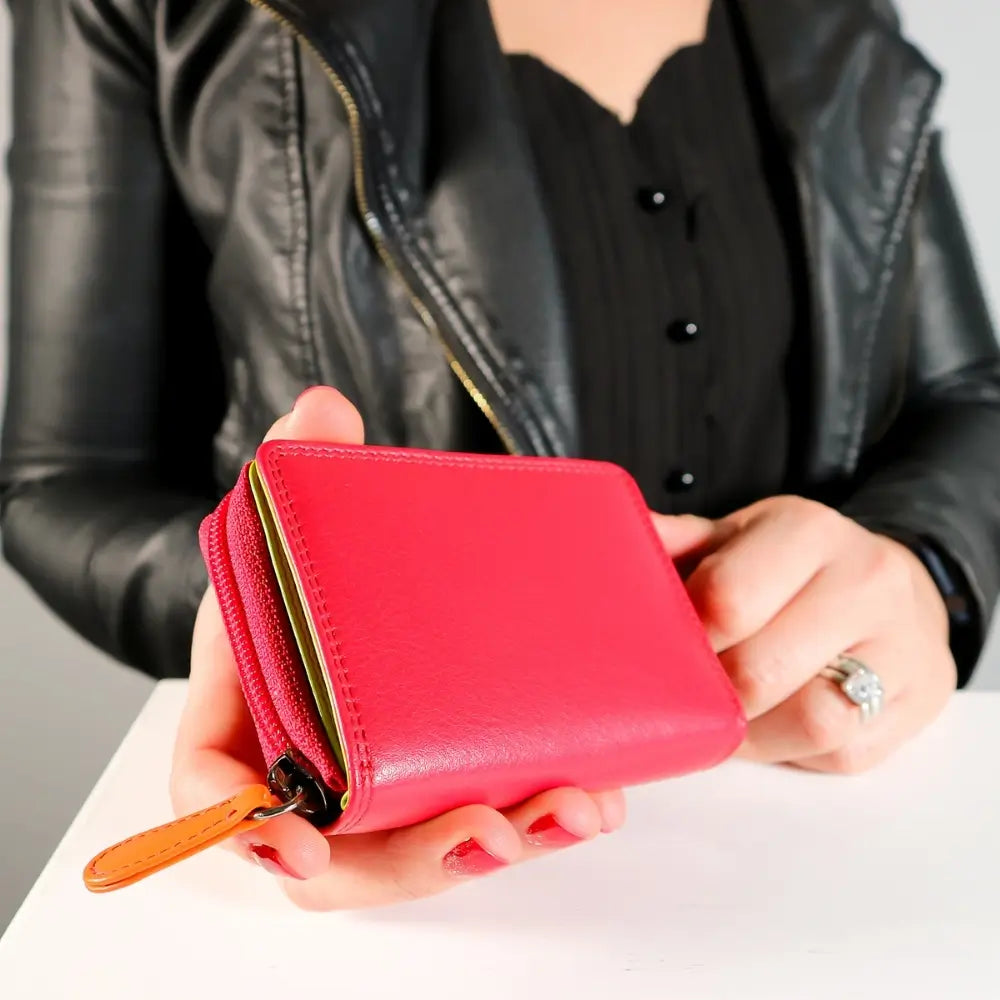 Person holding a red wallet with a blurred background
