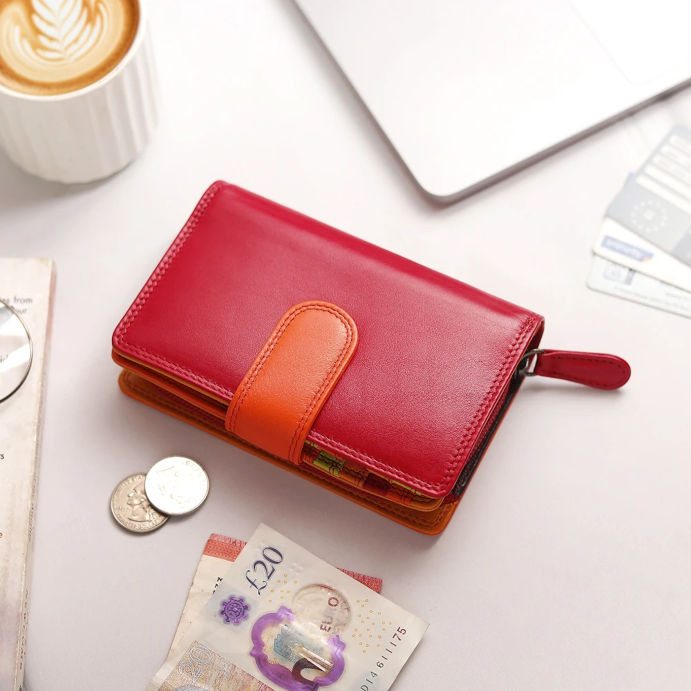 Red wallet with orange strap on a table with money and a cup of coffee.