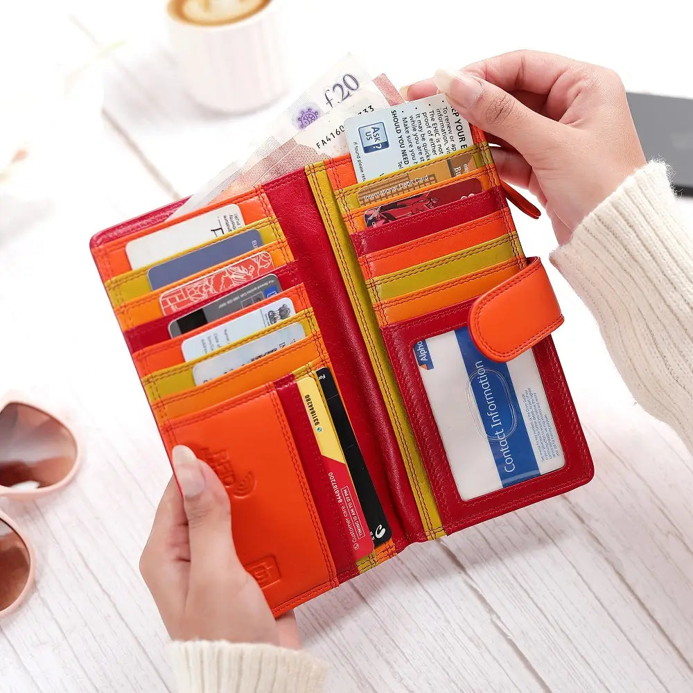 Red wallet with multiple card slots held open by a hand on a light surface.