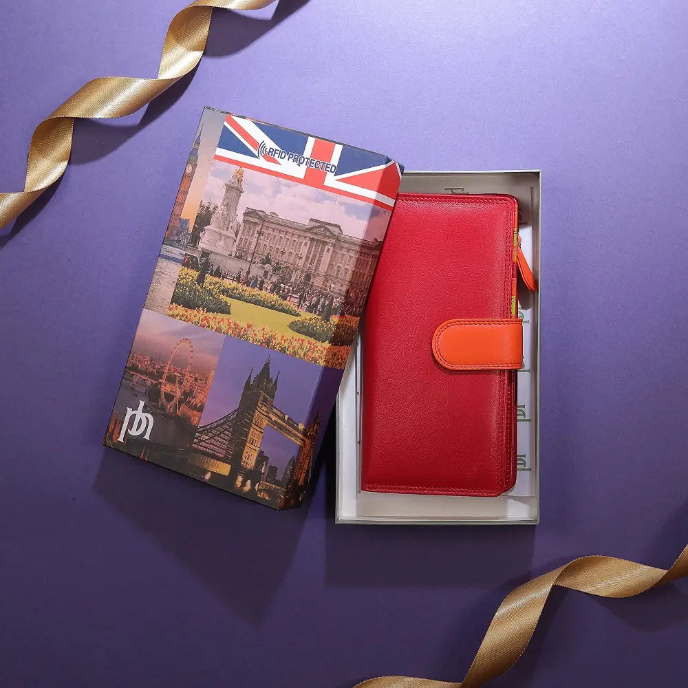Red wallet and travel guidebook with British landmarks on a purple background
