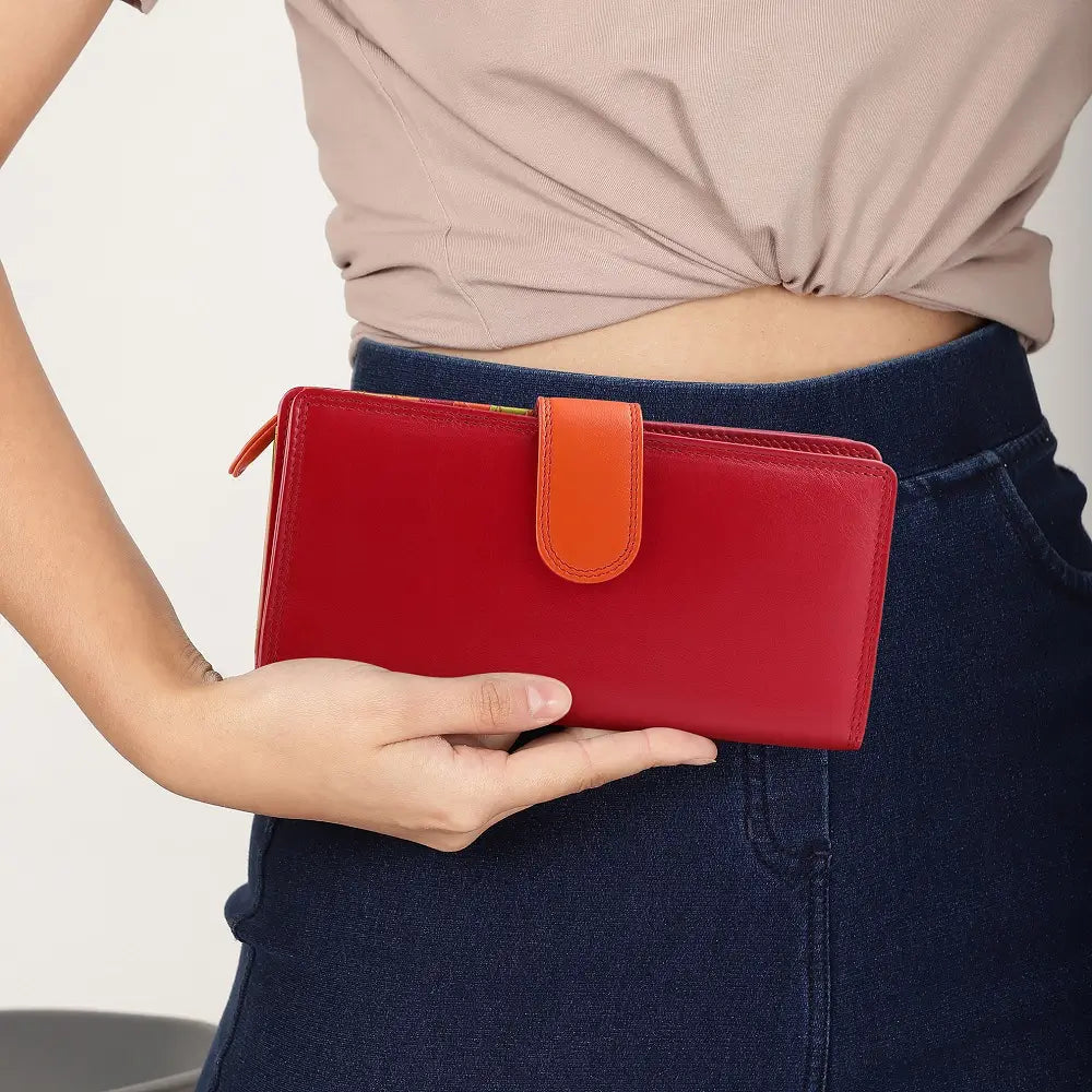 Person holding a red wallet with an orange strap against a neutral background