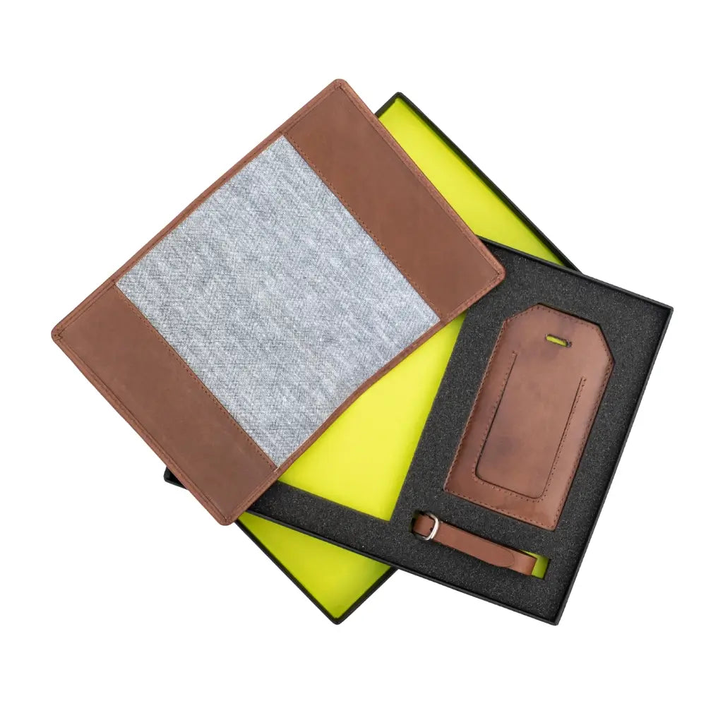 Passport holder and luggage tag set on a black tray with a green geometric background