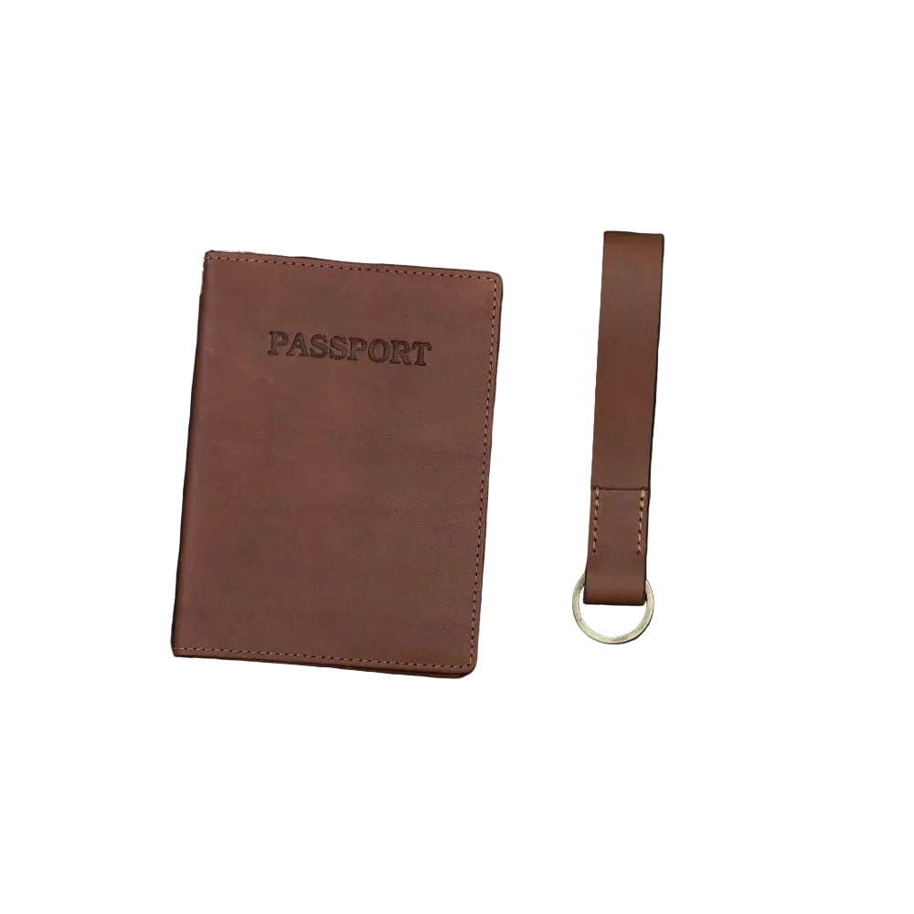 Brown passport holder and black travel wallet with a brown Keyring on a textured surface