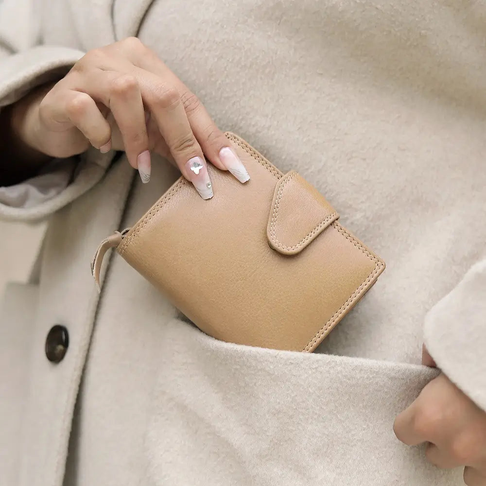 Person holding a sand wallet against a neutral background