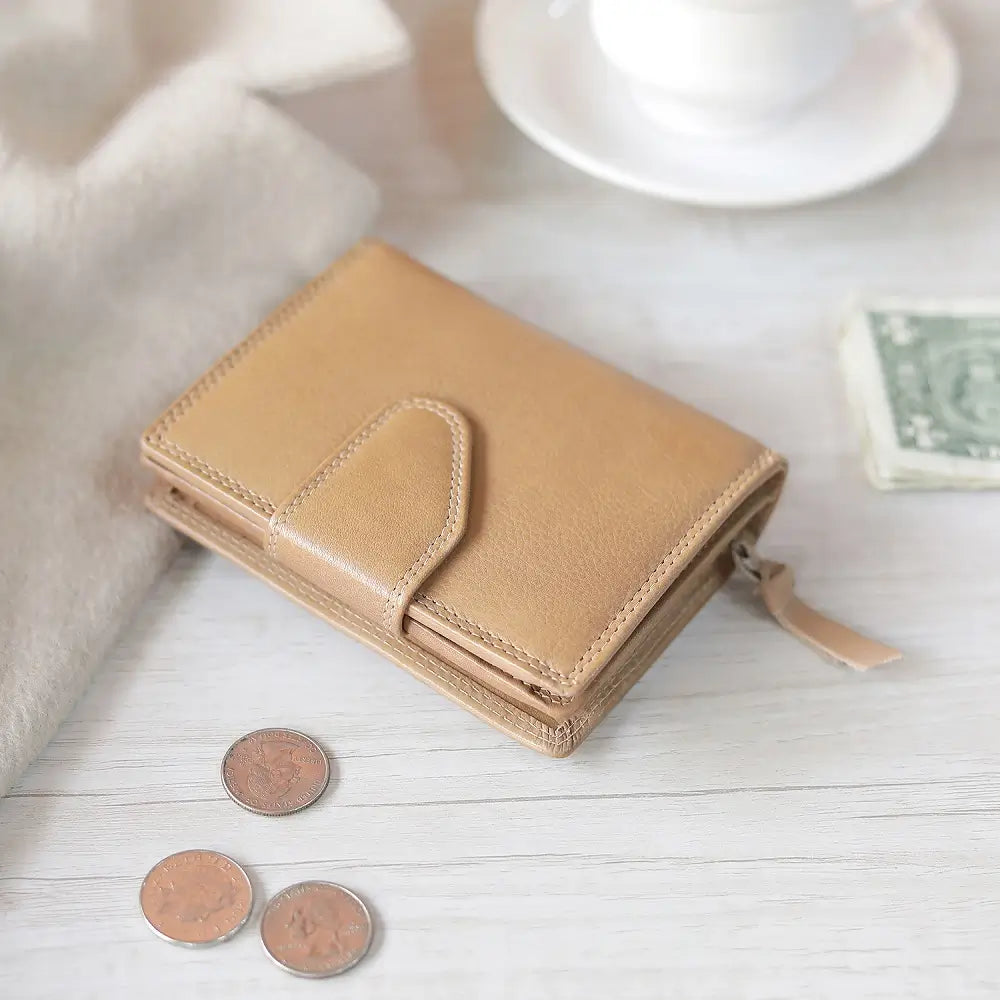 Sand wallet with coins on a light wooden surface