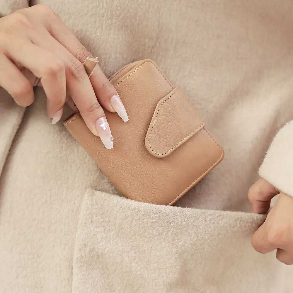 Person holding a sand wallet against a neutral background