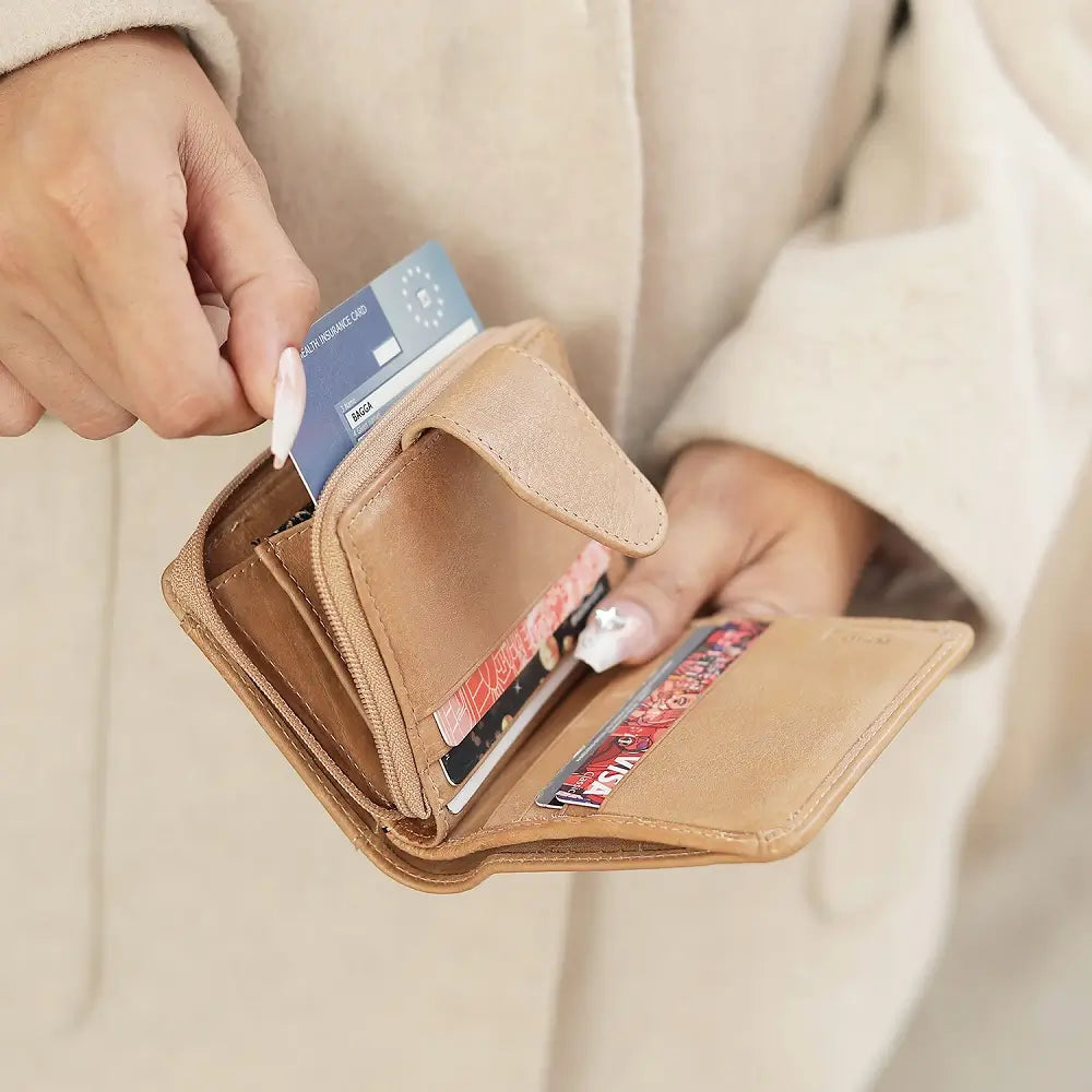 Person inserting a card into a sand wallet with a neutral background