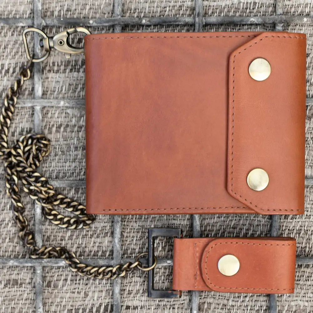 Tan leather wallet with chain on a textured surface