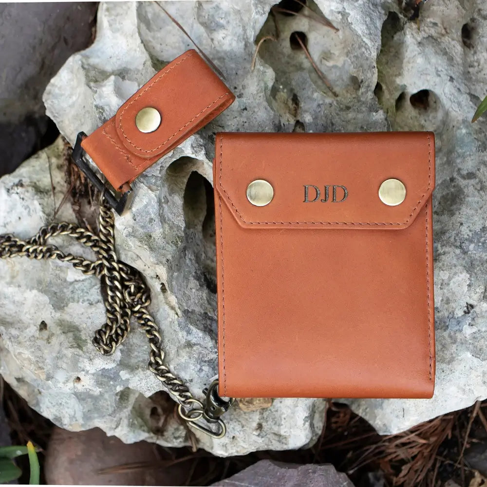 Tan leather wallet with chain on a rocky surface