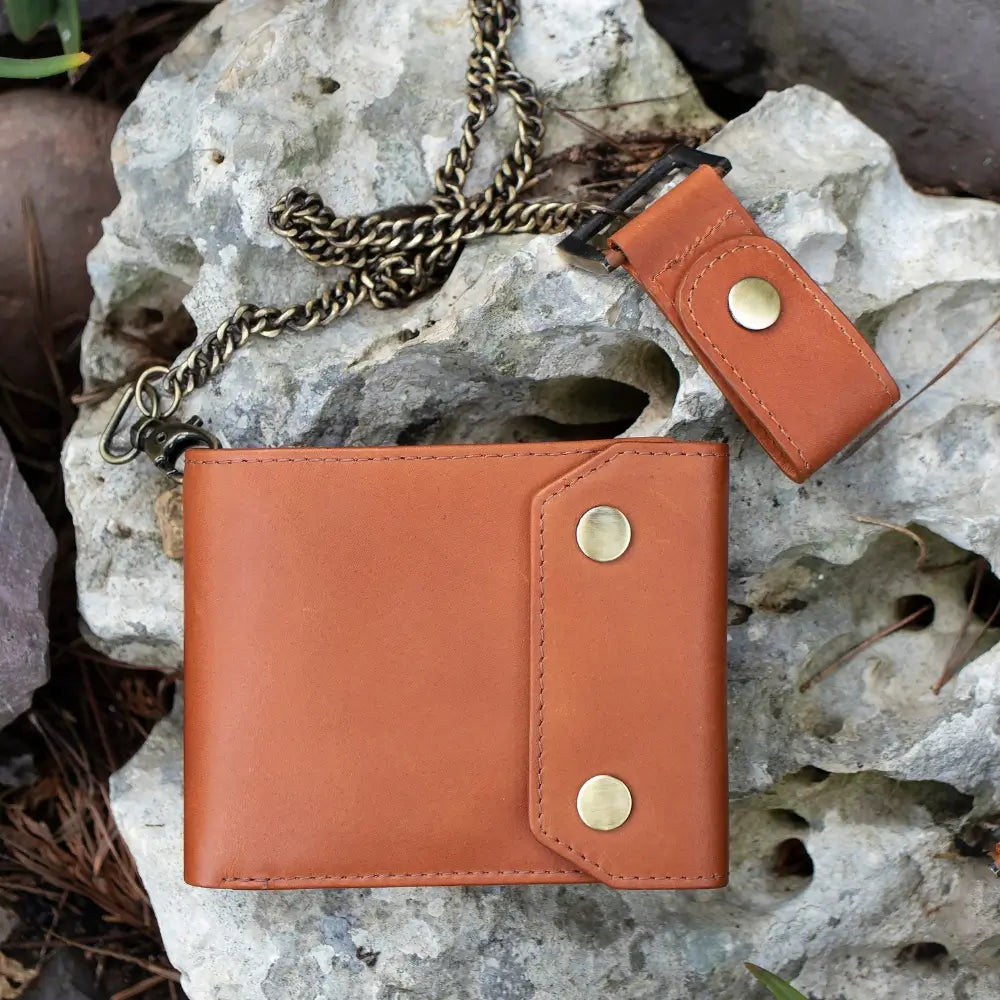 Tan leather wallet with chain on a rocky surface