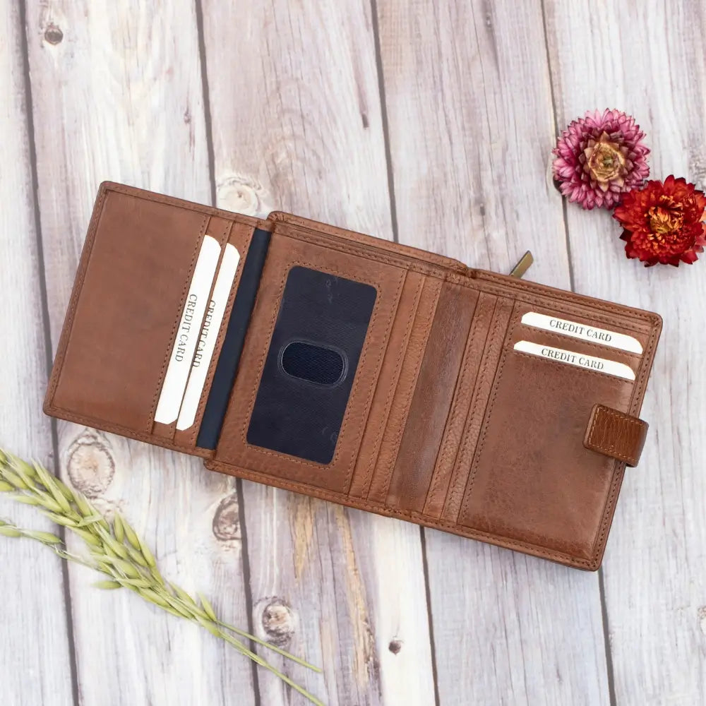 Brown leather wallet with card slots on a wooden surface with flowers