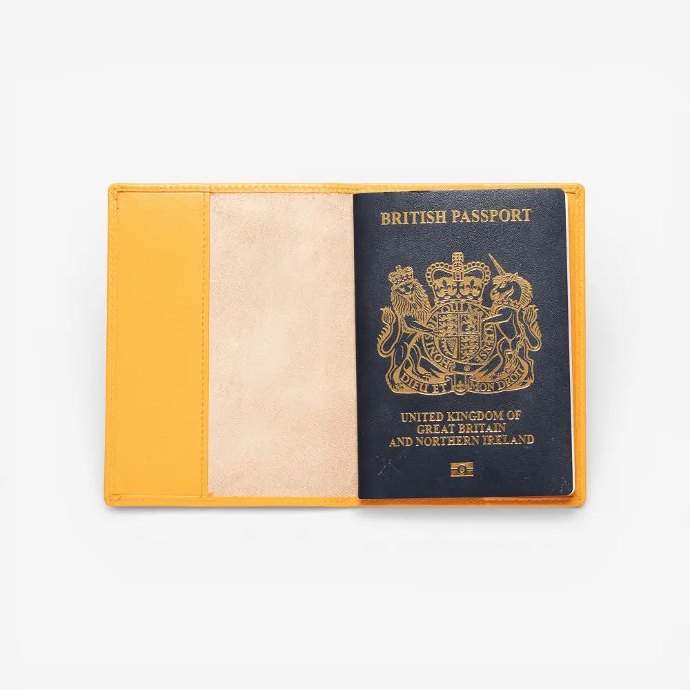 Yellow passport holder with a British passport inside on a white background