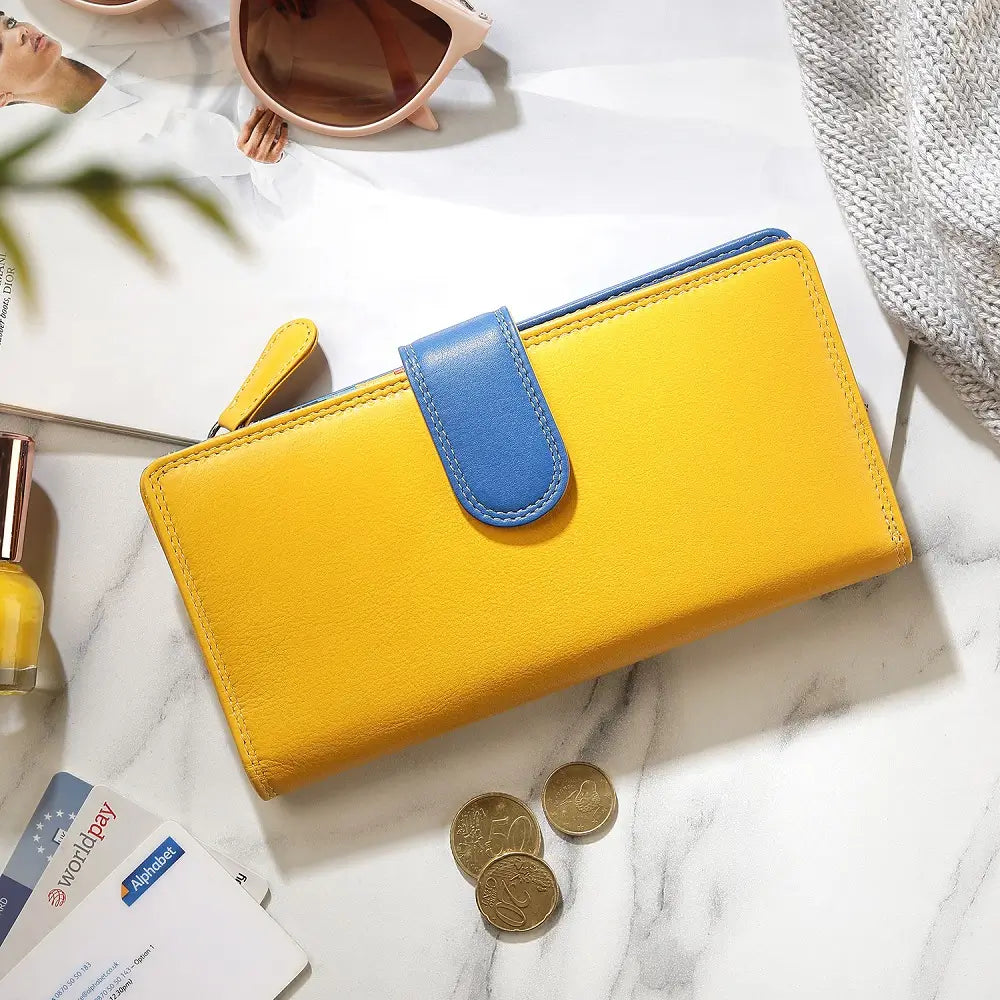 Yellow wallet with blue flap on a marble surface with coins and cards.