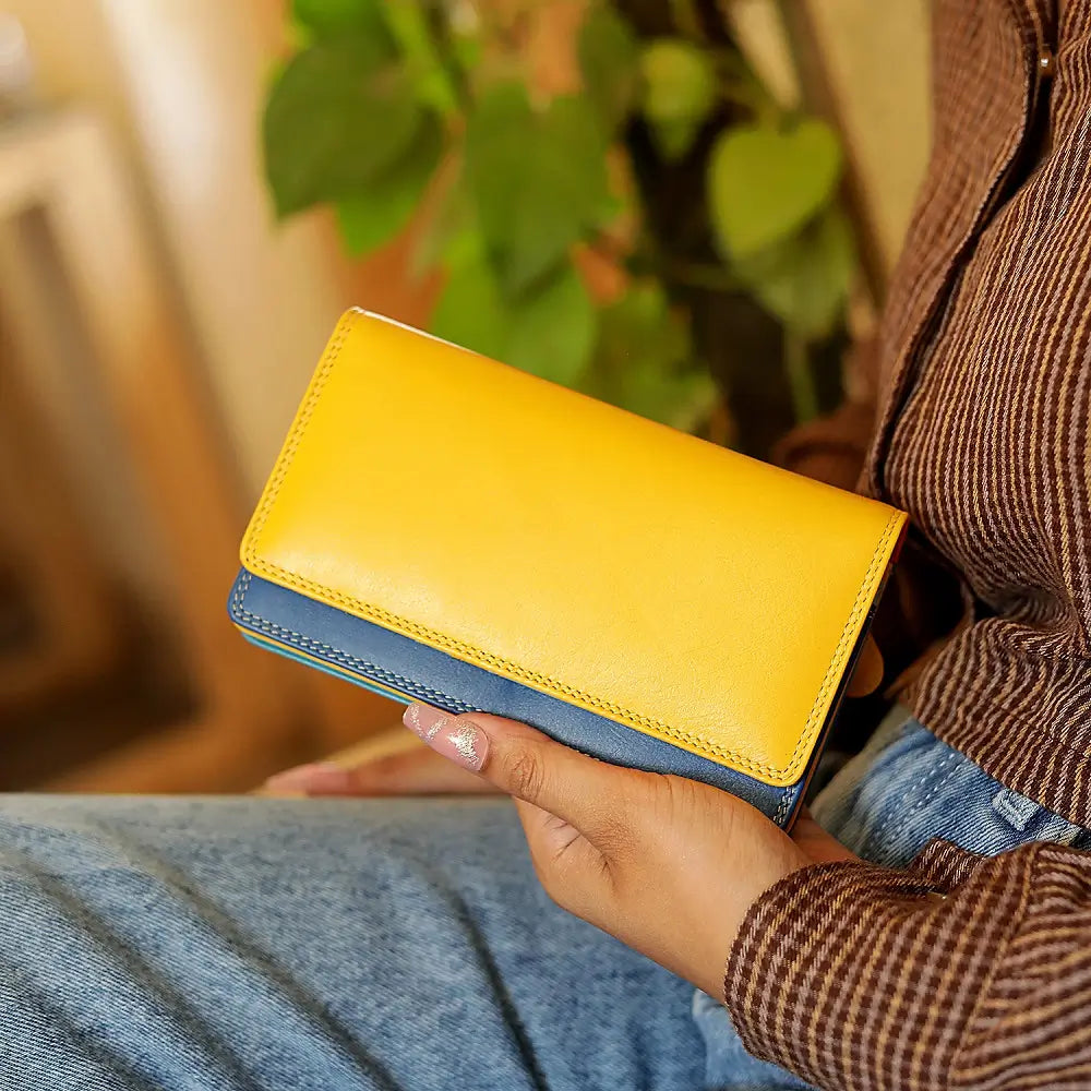 Person holding Yellow wallet with blue bottom section on a white background 