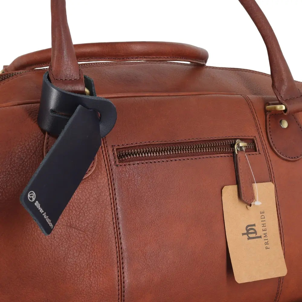 Brown leather bag with a visible brand tag on a white background