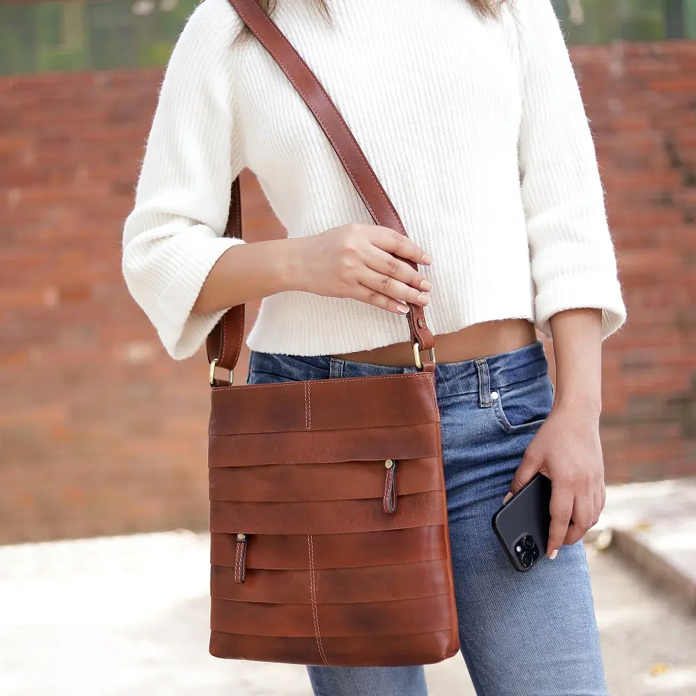 Woman carrying the Ridgeback 671 Layered Leather Crossbody Bag, showing its adjustable shoulder strap and layered leather design.