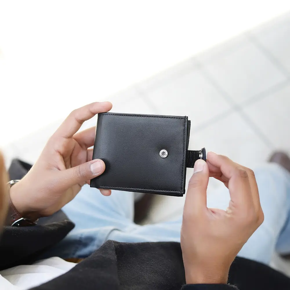 Person holding Basic Wallet Style 99 in black – genuine leather RFID bifold wallet with tab closure and coin pocket