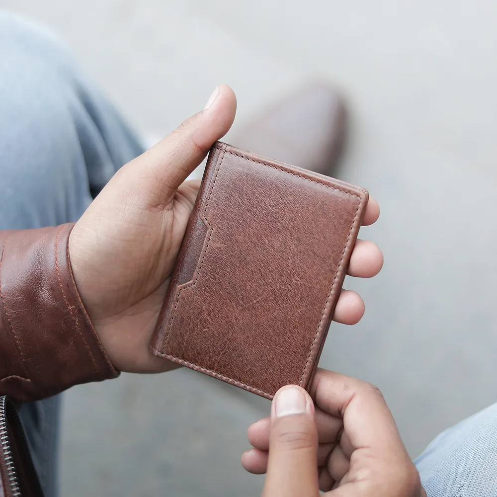 Man holding brown leather credit cardholder - Alperto 4275. Slim and stylish leather wallet with RFID security.