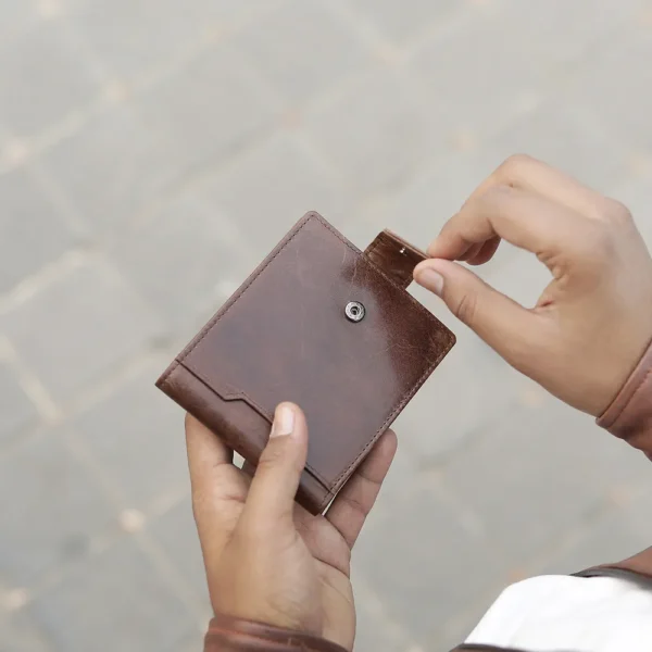 Close-up of tab button closure on the Alperto 4269 wallet in brown. Premium oiled leather with a distressed finish.