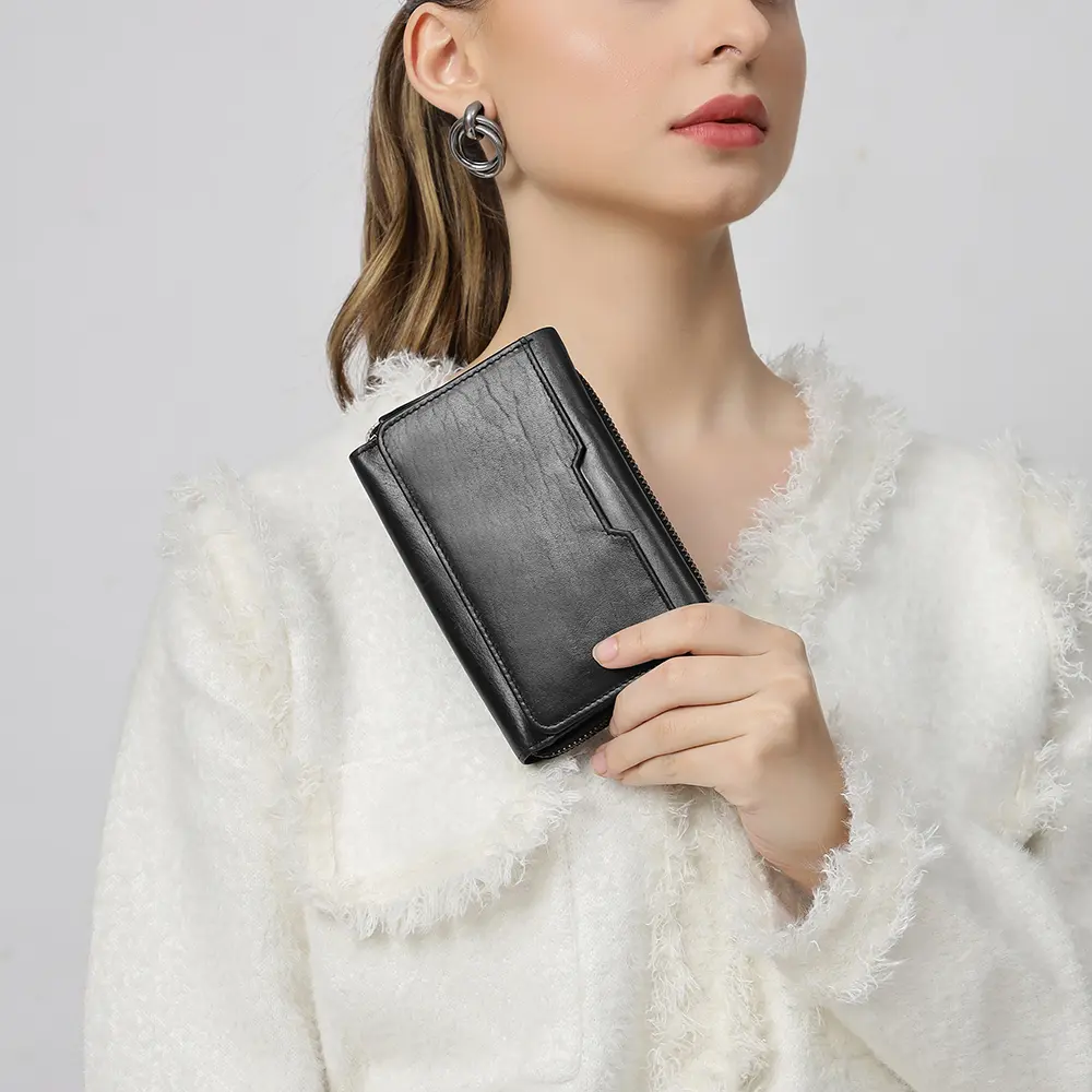 User holding the Medium black Trifold Purse in hand, highlighting its compact size and practical functionality for everyday use.