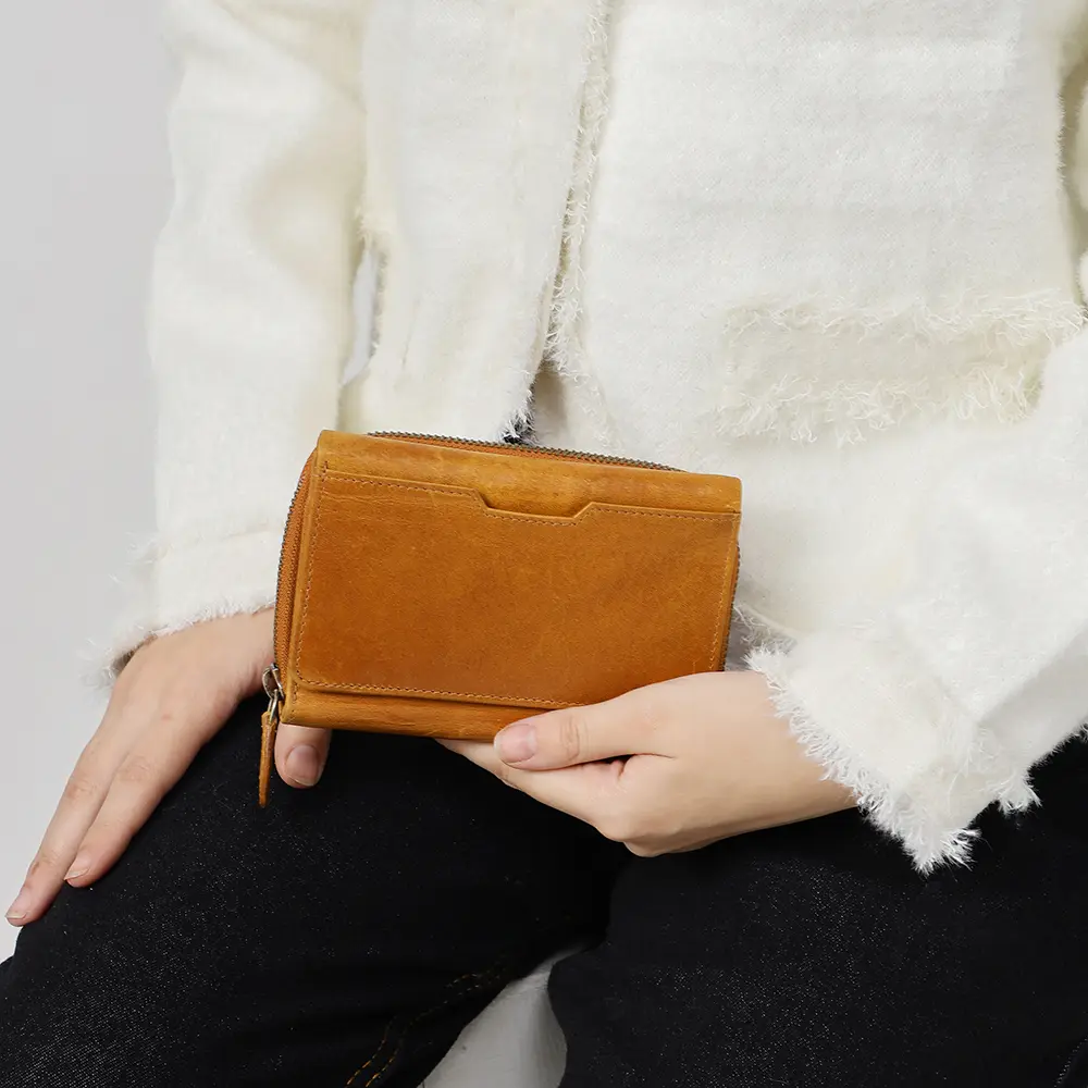 User holding the Medium Tan Trifold Purse in hand, highlighting its compact size and practical functionality for everyday use.