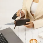 Brown leather zipped pen case on an office desk beside a coffee cup and laptop