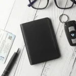 Vertical Leather-Lined Card Wallet Mayfair 2501 Black – Lifestyle View Black leather vertical card wallet on desk beside glasses, pen and card